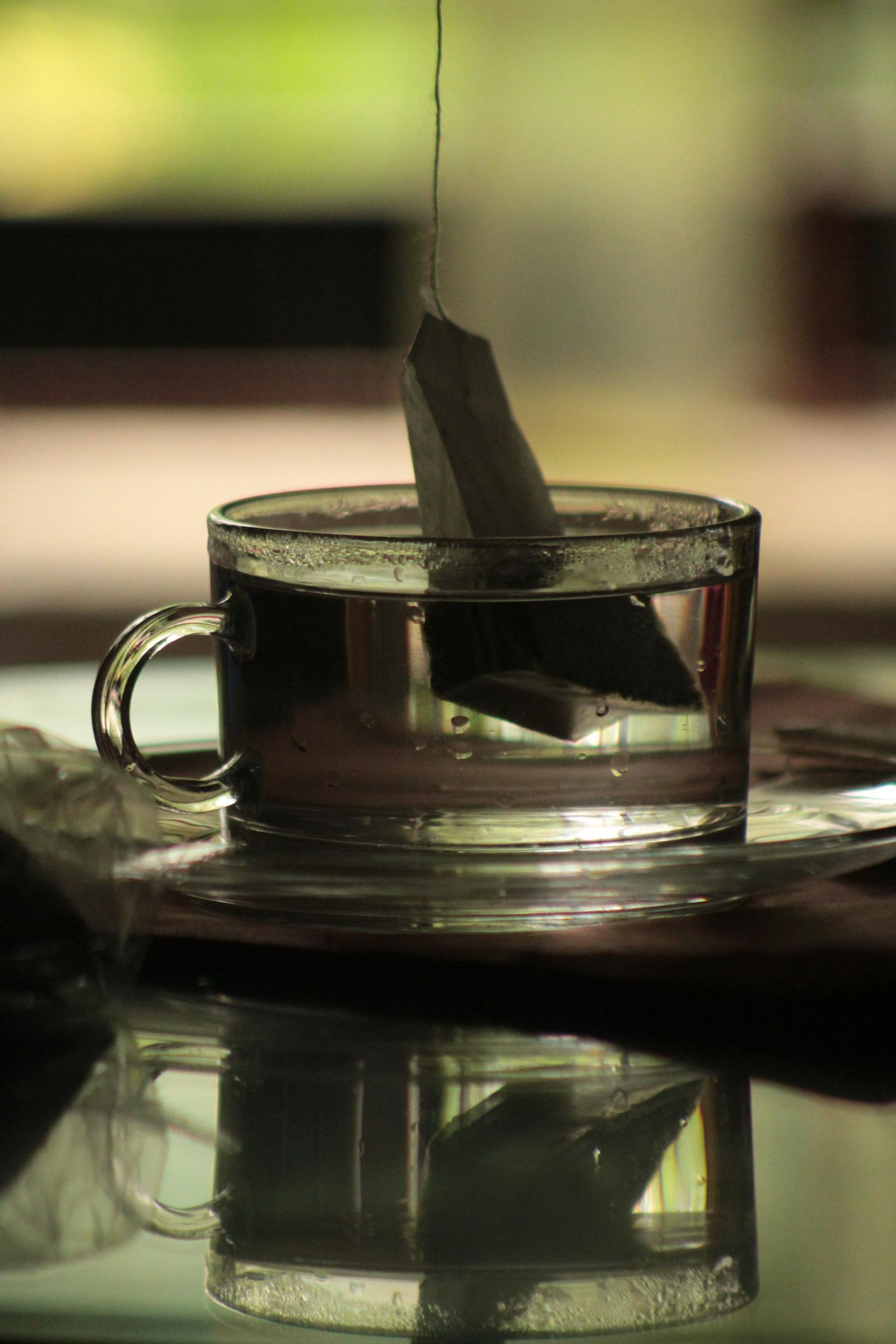 Bolsita de té infusionando en una taza de cristal