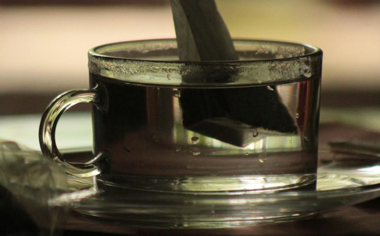 Bolsita de té infusionando en una taza de cristal